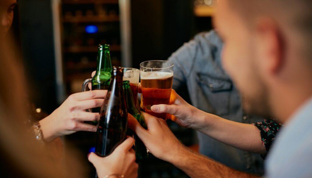 People doing a cheers with their beers.