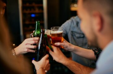 People doing a cheers with their beers.