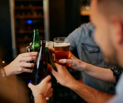 People doing a cheers with their beers.