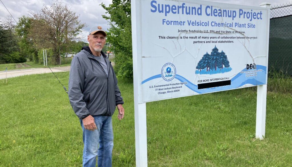 Gary Smith of St. Louis, Michigan, stands near the Superfund site sign at the former Velsicol plant.