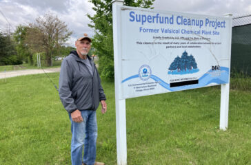 Gary Smith of St. Louis, Michigan, stands near the Superfund site sign at the former Velsicol plant.